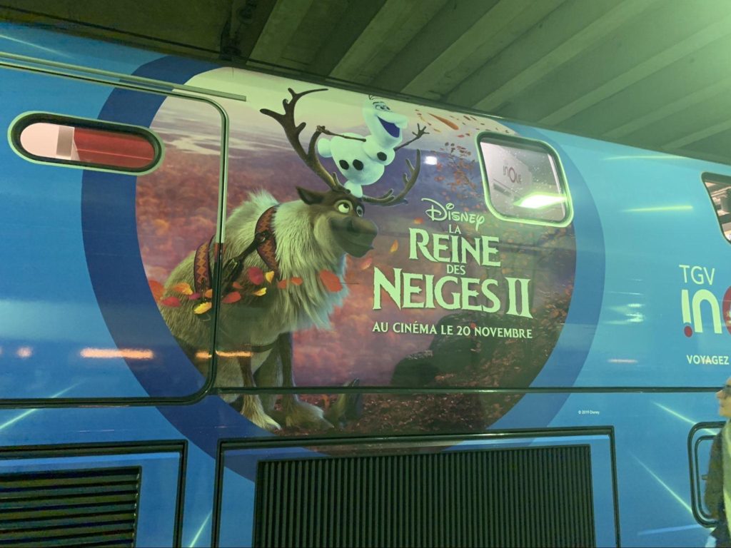 A bus with a picture of a reindeer on it, decorated with the theme of "reindeer" or "winter".